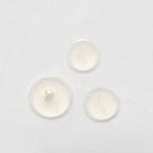 Three small, clear liquid droplets on a plain white surface, possibly from the LIFT & FIRM Anti-Aging Duo Serum Set by IREN Shizen, which contains Argireline Peptide.