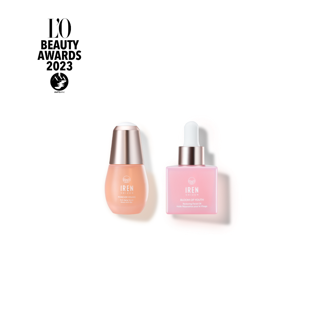 Two skincare products: One beige serum bottle with a rounded cap and "IREN Shizen" label, and one pink anti-aging serum bottle with a pump dispenser that boosts collagen production and bears the same "IREN Shizen" label.