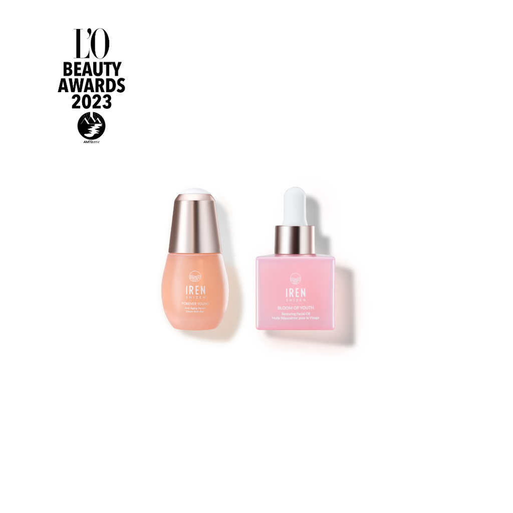 Two skincare products: One beige serum bottle with a rounded cap and "IREN Shizen" label, and one pink anti-aging serum bottle with a pump dispenser that boosts collagen production and bears the same "IREN Shizen" label.