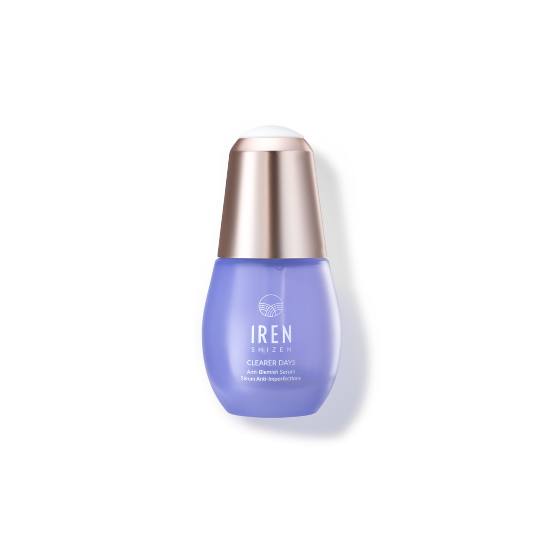 A blue bottle of skincare serum with a metallic cap, labeled "CLEARER DAYS Anti-Blemish Serum" by IREN Shizen, provides an effective niacinamide serum and acne treatment solution.