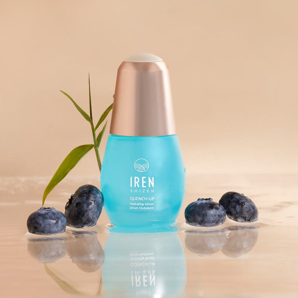 A bottle of DEW UP Hydrating Set with blueberries and an IREN Shizen DEW UP Hydrating Set next to it, showcasing Japanese onsen skincare.
